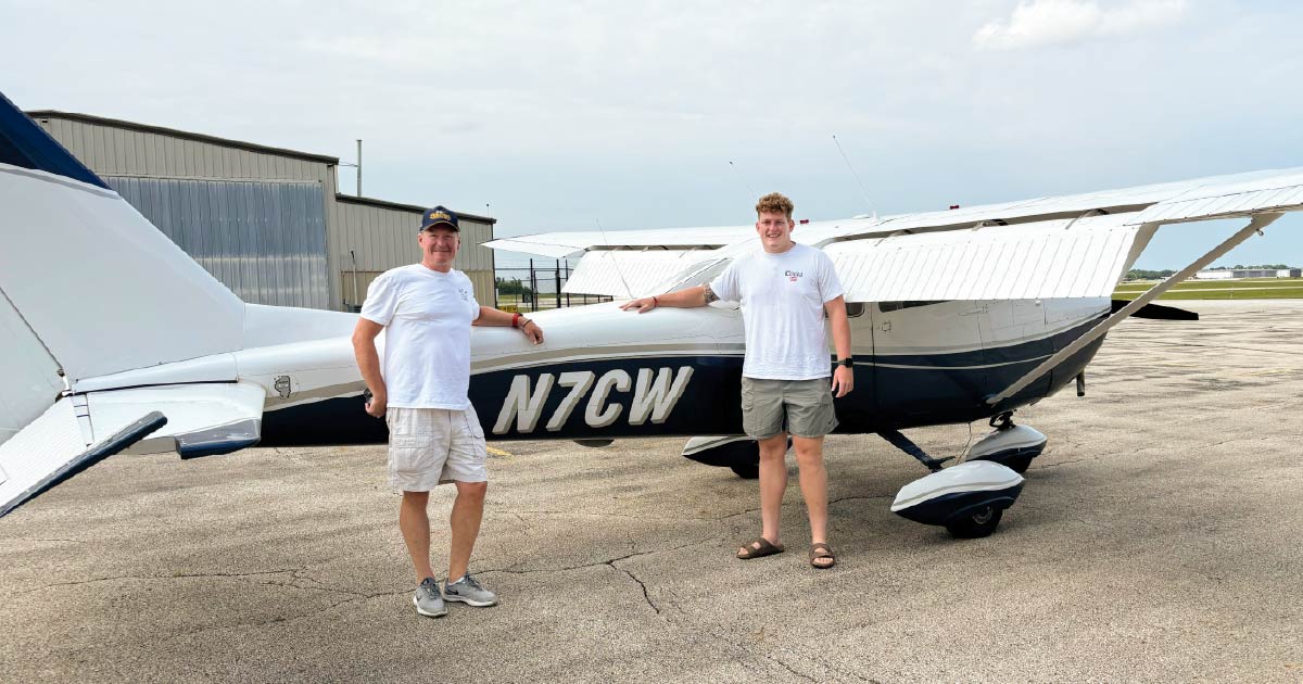 Luke Dalton and his father, Chris, pose in front of the family's plane.