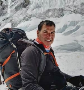 Leonard Forkas Jr. stands in a snowscape with a large backpack for hiking.
