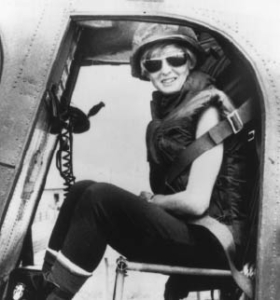 Jane (LaRowe) Hamilton-Merritt sits in a helicopter smiling.
