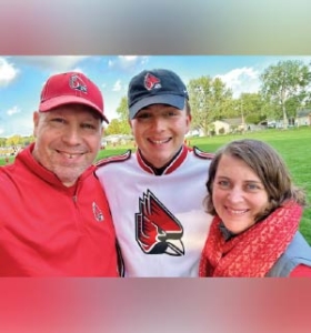 Rick Grandlund stands next to Connor and Candi Granlund in Ball State attire.