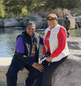 Rayford Crenshaw II poses in front of the Frog Baby statue with his wife.