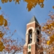 Bell Tower framed by fall trees with a blue sky in the background.