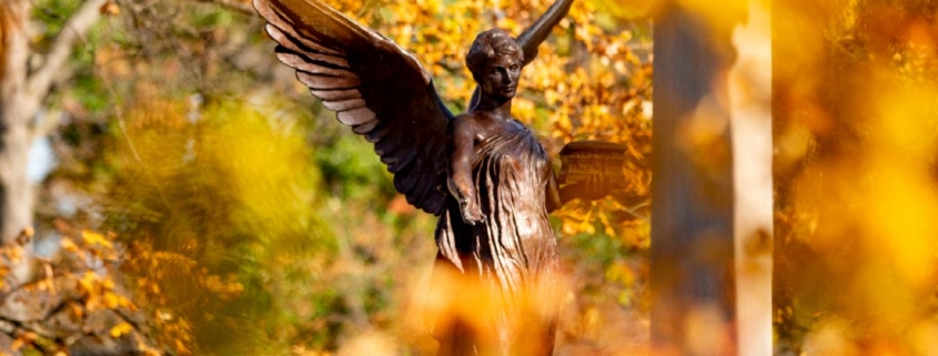 The Beneficence statue surrounded by fall foliage on Ball State University’s campus