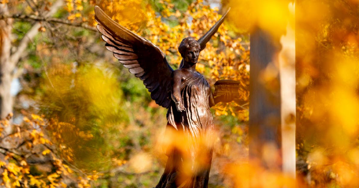 The Beneficence statue surrounded by fall foliage on Ball State University’s campus