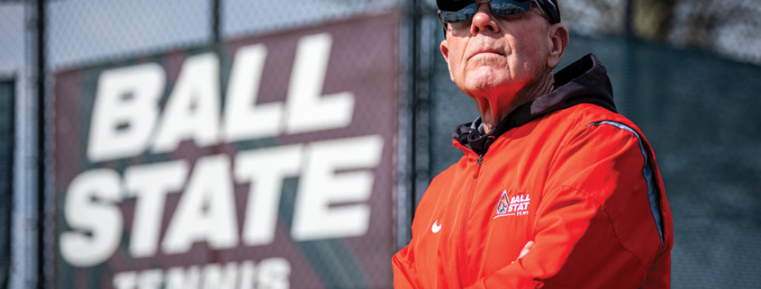 Bill Richards stands in front of tennis courts