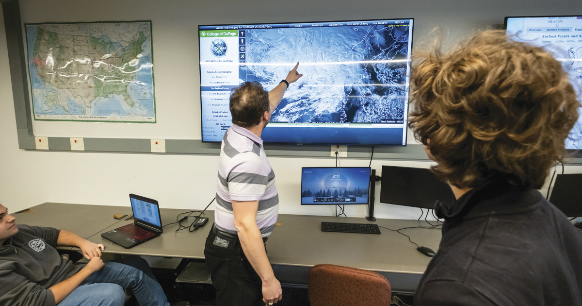 Meteorology student and professor looking at the screen with a storm cell on it.
