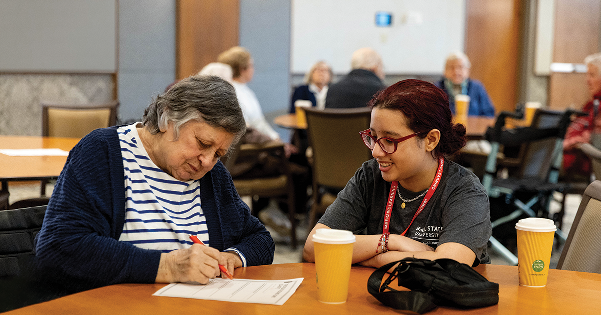 Woman with student writing at a table