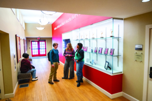 Students looking at a display case inside the honors house