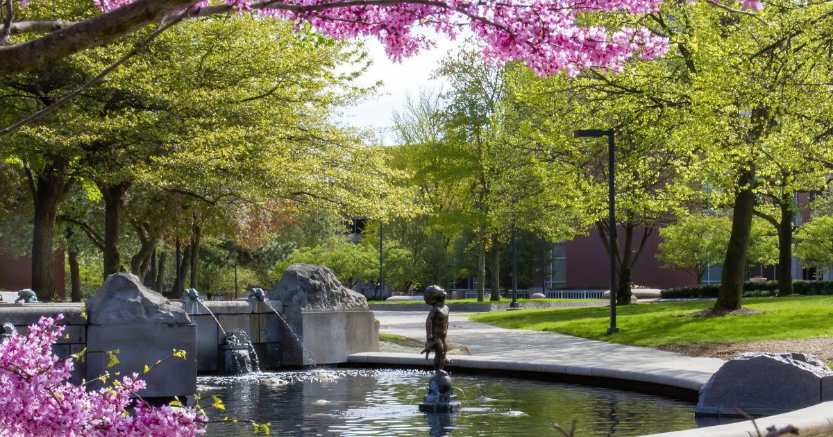 Frog baby statue on campus with spring flowers