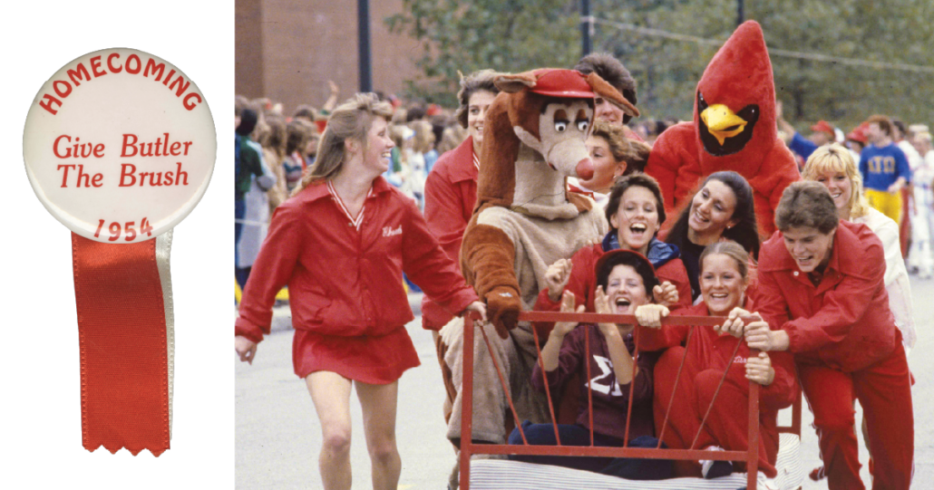 Students push anded bed down the road with two mascots riding on it.