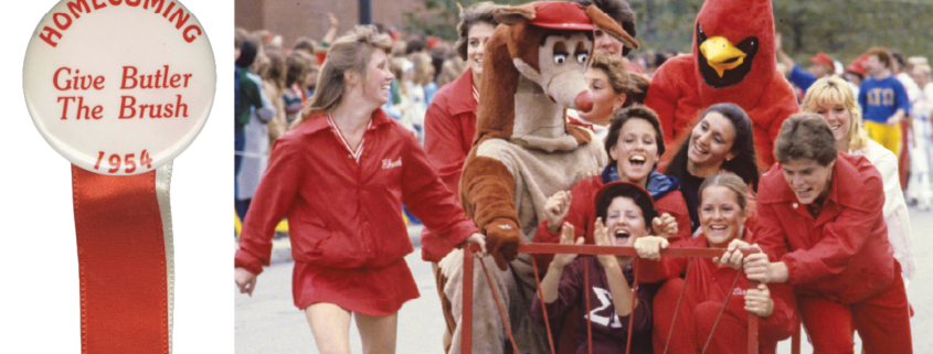 Students push anded bed down the road with two mascots riding on it.
