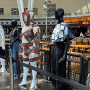 Mannequins lined up at the airport wearing handmade garments.