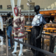 Mannequins lined up at the airport wearing handmade garments.