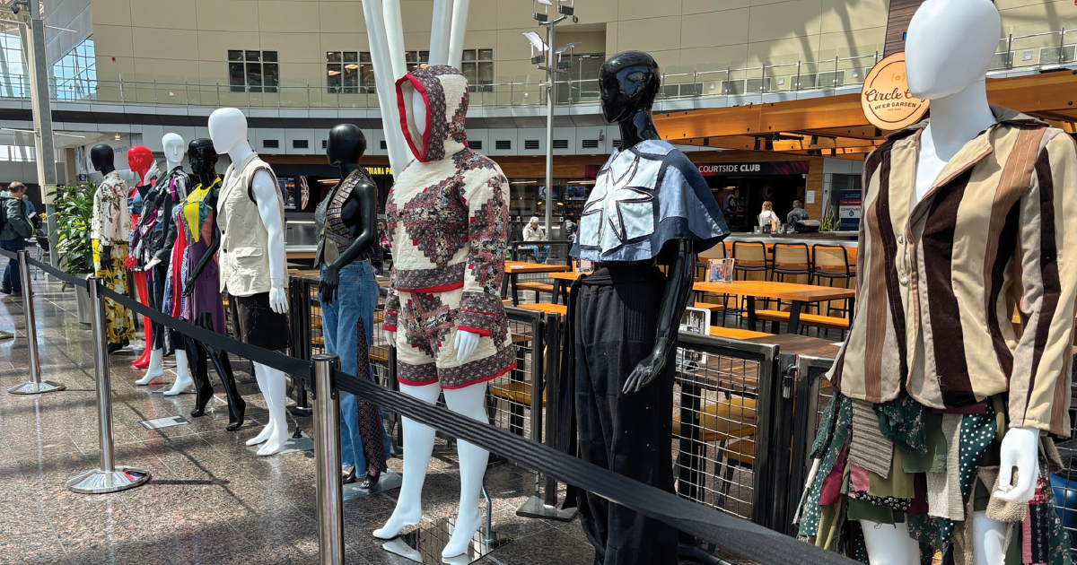 Mannequins lined up at the airport wearing handmade garments.