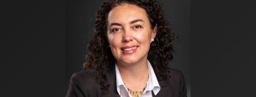 A portrait of a woman in a blazer against a black background