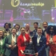A group of people pose for a photo while holding an award