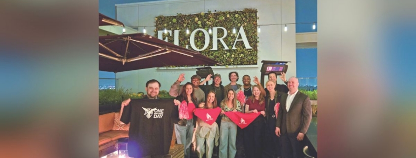 A large group poses for a photo holding banners reading "One Ball State Day""