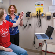 Doctor and patient in an exam room looking at the patients shoulder