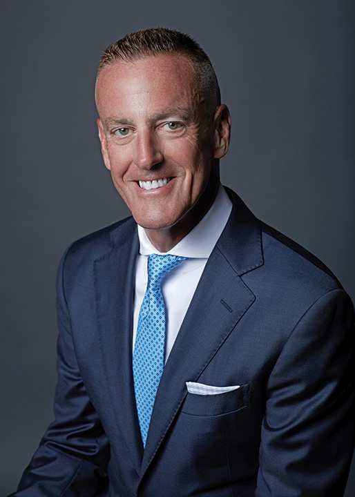 Portrait of Eric Foss in blue suit, white shirt and light blue tie