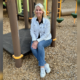 A woman sitting. on a playground.