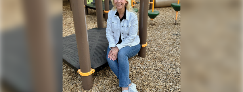 A woman sitting. on a playground.