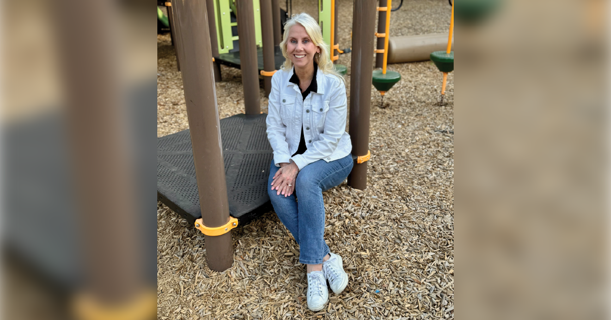 A woman sitting. on a playground. 